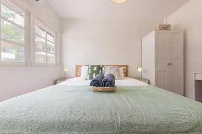a bedroom with a large bed with a green blanket at Oasis townhouse in the perfect location in Bangkok