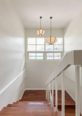 a white staircase with two lights and a window at Oasis townhouse in the perfect location in Bangkok