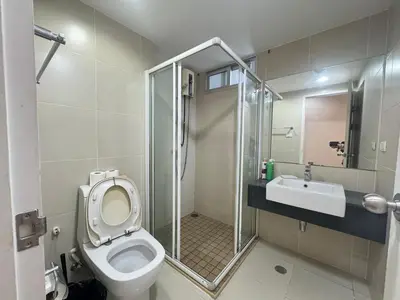 a bathroom with a toilet and a shower and a sink at Rama9 Luxe Suites in Bangkok