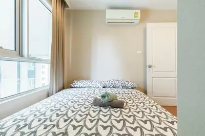 a bedroom with a bed with a stuffed animal on it at Rama9 Luxe Suites in Bangkok