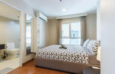 a bedroom with a bed and a large window at Rama9 Luxe Suites in Bangkok