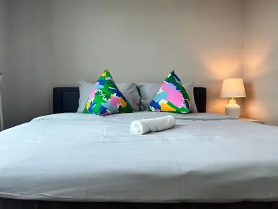 a bed with two pillows and a towel on it at Rama9 Luxe Suites in Bangkok