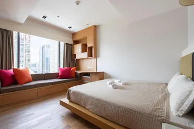a bedroom with a bed and a couch at M Estate Private Residence 3BR, Heart of Bangkok in Bangkok