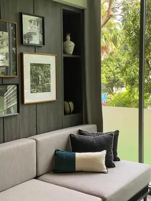 a couch with pillows in a room with a window at Madi Paidi Bangkok, Autograph Collection in Bangkok