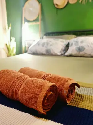 a couple of brown towels laying on a bed at Be Local BNB in Bangkok