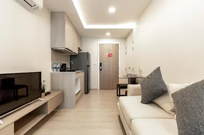 a living room with a couch and a kitchen at Bts thonglo 700m free wifi & gym in Ban Hua Khao Sisiat