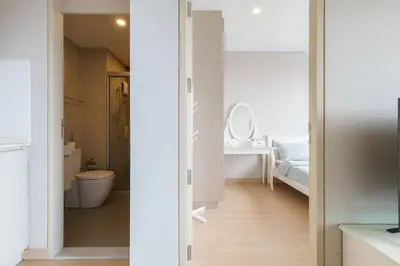 a white bathroom with a toilet and a sink at Lumpini Suite Phetchaburi Siam Square Nana in Ban Non Phatthana