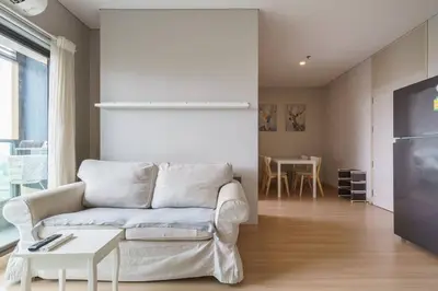 a living room with a couch and a table at Lumpini Suite Phetchaburi Siam Square Nana in Ban Non Phatthana