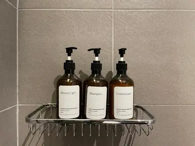 three bottles of wine sitting on a shelf in a bathroom at Vélin Khaosan - 2nd Floor apartment with 2Bedrooms in Bangkok