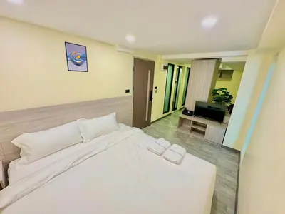 a bedroom with a white bed and a television at Nona Hotel, Bangkok in Makkasan