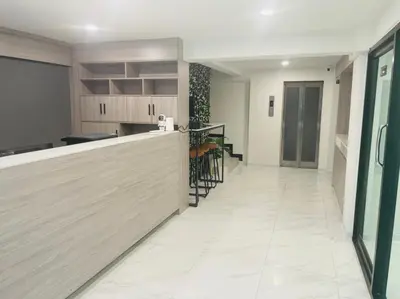 a kitchen with a counter and a dining room at Nona Hotel, Bangkok in Makkasan