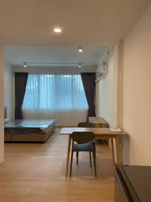 a room with a bed and a table and a desk at 33 Avenue in Bangkok