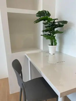 a potted plant sitting on a white desk with a chair at 33 Avenue in Bangkok