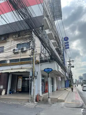 a building on the side of a city street at Jaruchok Apartment in Bangkok