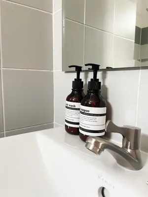 two bottles of soap sitting on a bathroom sink at Jaruchok Apartment in Bangkok