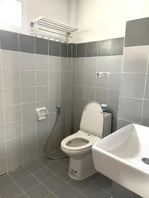 a bathroom with a toilet and a sink at Jaruchok Apartment in Bangkok