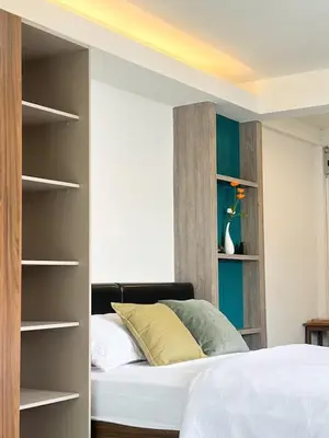 a bedroom with a bed and open shelves at Jaruchok Apartment in Bangkok
