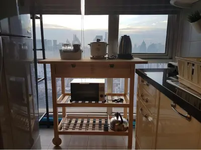 a kitchen with a table with a microwave and a window at Sukhumvit Boutique Suite : Soi 13/ 10min. from BTS Nana station in Bangkok