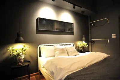 a bedroom with a bed with a tv on the wall at STAY-DIUM House Huamark in Ban Bang Toei (1)