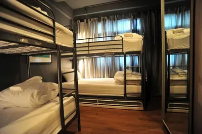 a room with three bunk beds with white sheets at STAY-DIUM House Huamark in Ban Bang Toei (1)