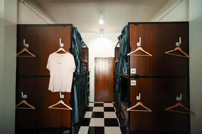 a dressing room with wooden doors and hangers at Noir Cafe And Hostel Chinatown Bangkok in Chinatown