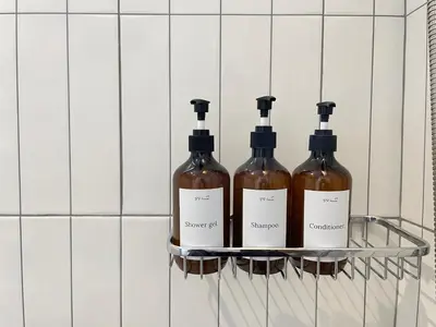 three bottles of wine on a shelf in a bathroom at Vélin Khaosan - 3rd Floor apartment with 2Bedrooms in Bangkok