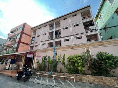 a motorcycle parked in front of a building at Pimravee Apartment (Yaek 8) in Ban Zong Katiam