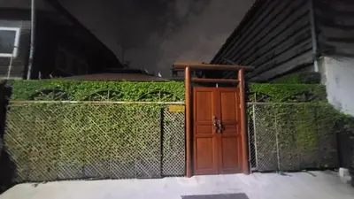 a wooden door in front of a fence at Aran Cottage Ngamwongwan The Pool Villa in japanese Garden in Nonthaburi