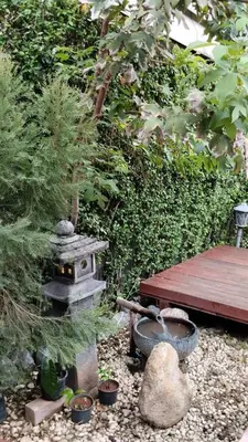 a garden with a wooden table and a stove at Aran Cottage Ngamwongwan The Pool Villa in japanese Garden in Nonthaburi