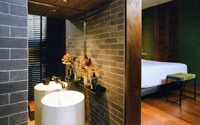 a bathroom with a sink and a bed in a room at Na Tanao 1969 in Bangkok