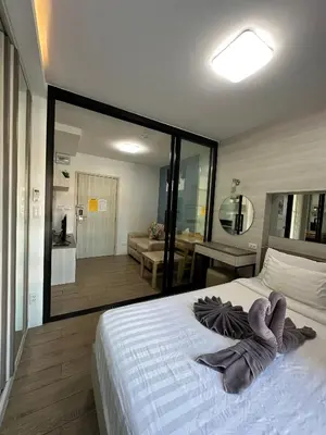 a bedroom with a white bed with a large mirror at ABoutNont HOTEL & MANSION in Nonthaburi