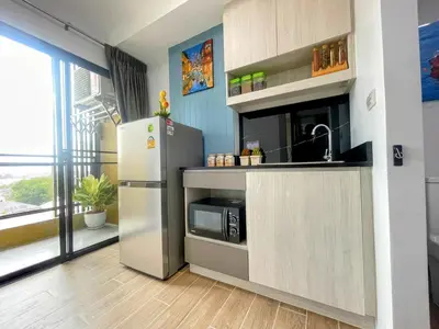 a kitchen with a refrigerator and a microwave at ABoutNont HOTEL & MANSION in Nonthaburi