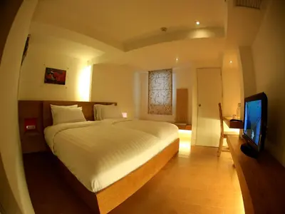 a bedroom with a large bed and a television at Silom One in Bangkok