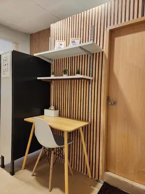 a wooden table and a chair next to a door at 205-Olan Place Homely room Free Wi-Fi and Near BTS line in Ban Yang
