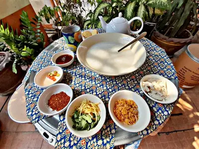 a table with bowls of food on a table at Worakarn Apartment 3 in Bangkok