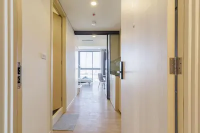 a hallway with a door and a room with a chair at Loft Pool Superior Suite Near jodd Night Market 500mbps Wi-Fi Twin in Bangkok