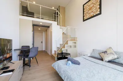 a living room with a bed and a staircase at Loft Pool Superior Suite Near jodd Night Market 500mbps Wi-Fi Twin in Bangkok