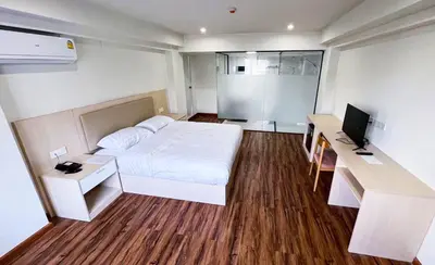 a bedroom with a bed and a desk with a computer at Lucky Elephant Hotel in Ban Bang Toei (1)