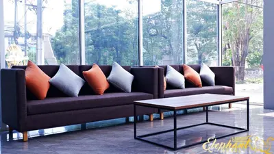 a couch with pillows and a coffee table in a room at Lucky Elephant Hotel in Ban Bang Toei (1)