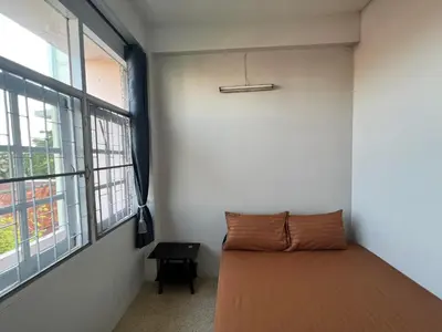 a bedroom with a bed and a large window at Merry V Guesthouse in Bangkok