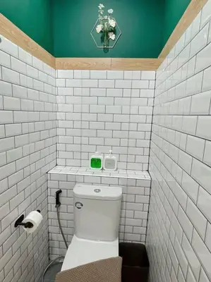 a small bathroom with a toilet and a green wall at Entire floor,Decorated cozy home, near Grand Palace in Bangkok
