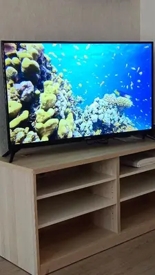 a flat screen tv sitting on top of a wooden entertainment center at Elio Del Ray condo feel resort in Bangkok