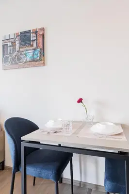 a dining table with two chairs and a painting on the wall at Bangkok city center-thong lo-rca-high-rise one-bedroom in Bangkok