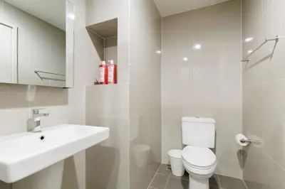 a white bathroom with a toilet and a sink at Bangkok city center-thong lo-rca-high-rise one-bedroom in Bangkok