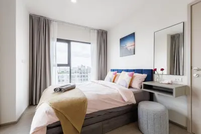 a bedroom with a bed and a large window at Bangkok city center-thong lo-rca-high-rise one-bedroom in Bangkok