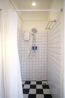a bathroom with a shower with a black and white checkered floor at SANT Bangkok at Khaosan Road in Bangkok