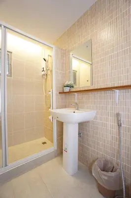 a bathroom with a sink and a shower with a mirror at Maruay Living Apartment (Khaosan/Chinatown/Samyot MRT) in Bangkok