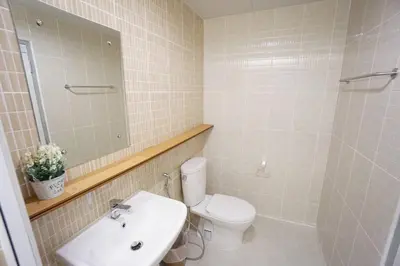 a bathroom with a toilet and a sink and a mirror at Maruay Living Apartment (Khaosan/Chinatown/Samyot MRT) in Bangkok