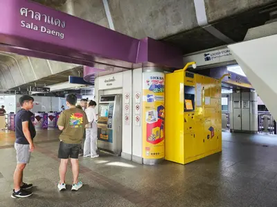 a group of people standing in front of a sales vending machine at PB home 1 min to BTS Saladaeng & MRT Silom in Bang Rak