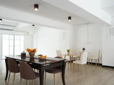 a dining room with a black table and chairs at RoomQuest IT Square Don Mueang Airport in Bangkok